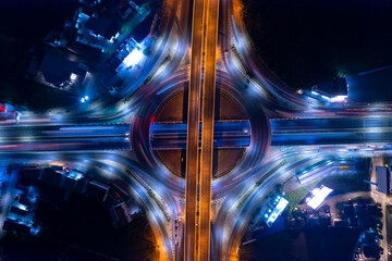 Aerial view of car traffic transportation above circle roundabout road in Asian city. Drone aerial view fly in circle, high angle. Public transport or commuter city life concept of economic and energ