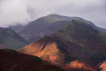 Beautiful landscape Autumn image of view from Walla Crag in Lake District, over Derwentwater looking towards Catbells and distant mountains with stunning Fall colors and light