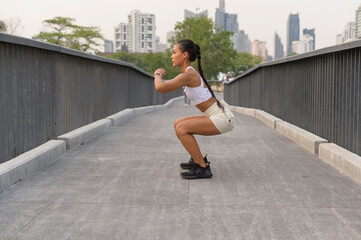 Fototapeta premium A young fitness woman in sportswear exercising in city park, Healthy and Lifestyles.