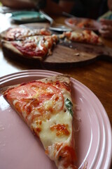 child eating delicious pizza on the wooden plate close-up