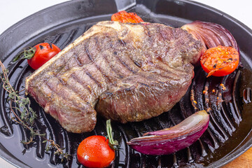 Grilled premium rib eye beef steak in the pan, cooking steak in the kitchen on a dark background, top view