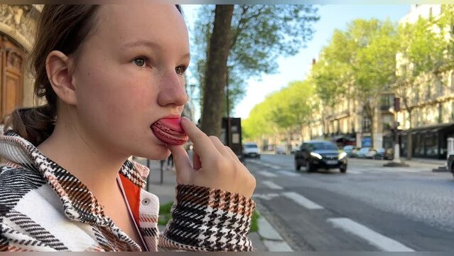 Teenage girl brown-haired woman with a mole above her lip eats makarun close-up slowly biting it off and blows with pleasure. High quality 4k footage