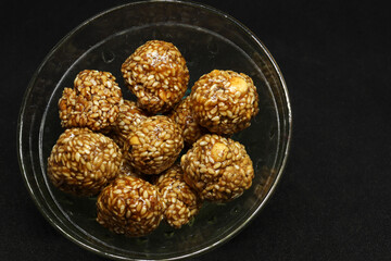 The sweet sesame balls are in a cup. On a black background