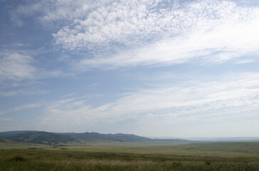 Beautiful clouds in the sky in summer. The sky is over the steppe.