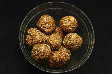 The sweet sesame balls are in a cup. On a black background