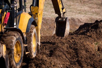 Wheel excavator loader is digging the soil at the construction site. © sergiophoto