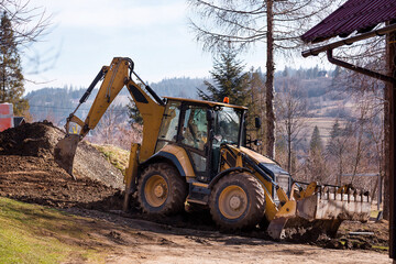 Wheel excavator loader is digging the soil at the construction site.