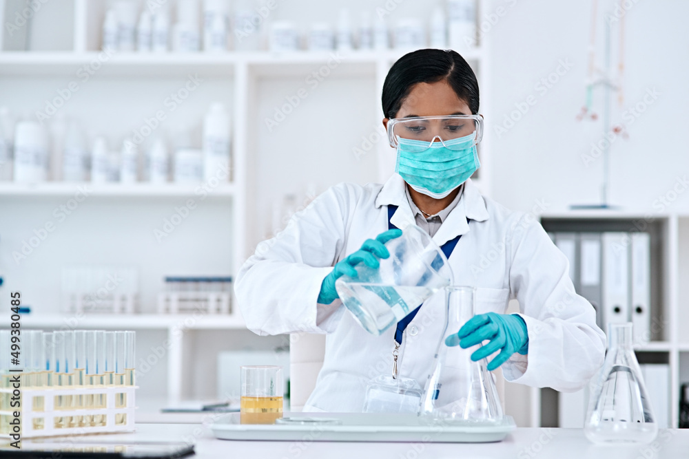 Poster The solution lies in your hands. Cropped shot of an attractive young female scientist transferring a clear liquid from a beaker to a conical flask while working in a laboratory.