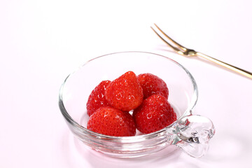 ガラス皿に盛ったイチゴとフォーク