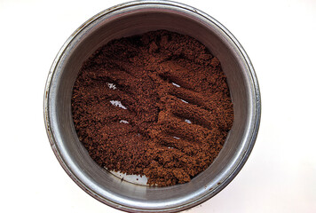 two ground coffee varieties in one coffee pot on a white background top view.