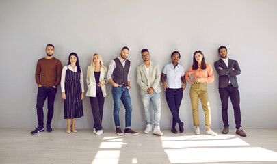 Portrait of diverse multiethnic businesspeople pose near grey wall background show unity and leadership. Multicultural employees or colleagues demonstrate diversity at workplace. Teamwork concept.