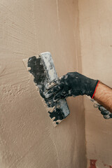 Worker applying putty mortar on the balcony wall