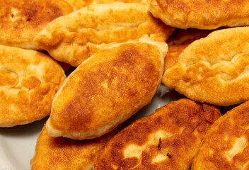 Pies are fried in oil in a frying pan.