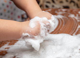 The boy plays with soap suds