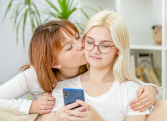 Happy lesbian couple embracing and using smartphone.  Lesbian couple concept