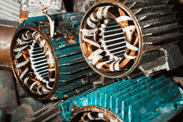 Broken electric motors being repaired in a garage. Stator, industrial electrical equipment close-up