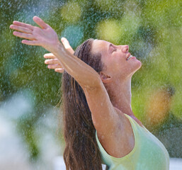 I feel alive. Side view of a young woman standing happily in the rain.