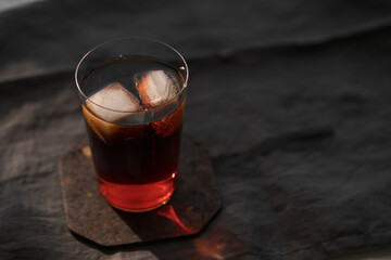 Cola with ice in tumbler glass on wood table with copy space