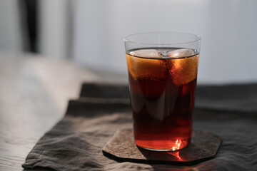 Cola with ice in tumbler glass on wood table with copy space