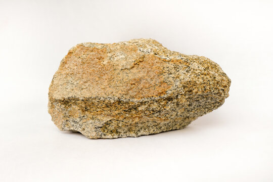 Macro shooting of raw specimen biotite granite gneiss rock isolated on white background.