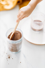 The children make glass of hot cocoa, closeup soft focus. Hot milk beverage. Breakfast drink.