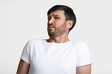 Disgusted Man Smelling Unpleasant Odor Expressing Negative Emotions, White Background