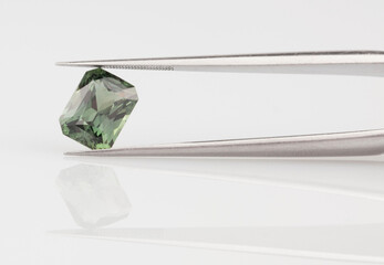 Green Sapphire Held in Tweezers. 