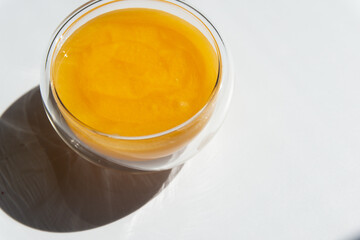 texture of golden honey in a transparent container on a white background free space for text.sunflower honey
