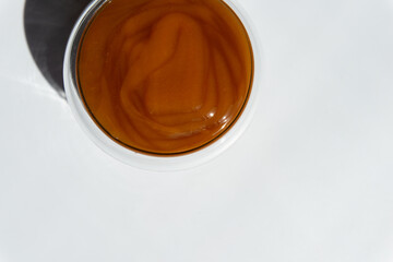 texture of brown honey in a transparent container on a white background free space for text.buckwheat honey