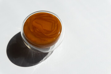 texture of brown honey in a transparent container on a white background free space for text.buckwheat honey