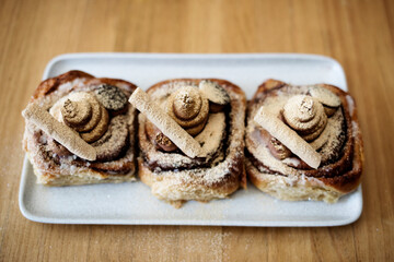 Three cinnamon rolls from above with chocolate bars and gold dust sprinkled