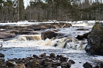 Raging river between forests.