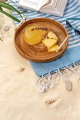 Cold pineapple cocktails on a wicker tray on beach with white sand. Summer sea vacation and travel concept. Exotic summer drinks.