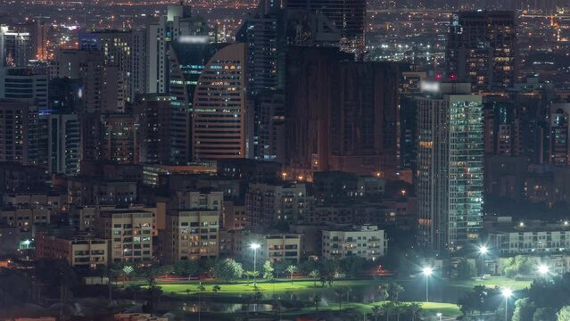 Aerial view of greens and al barsha heights district area night timelapse from Dubai marina.