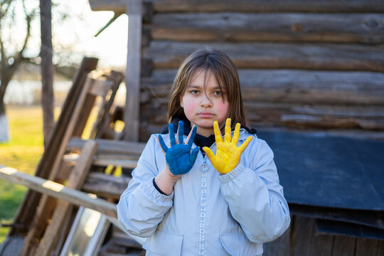 A child with the flag of Ukraine. Sadness longing hope. Children's sadness from the war. Evacuation of civilians. Freedom to Ukraine.
Hands painted in Ukraine flag