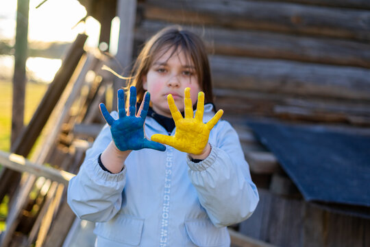 A child with the flag of Ukraine. Sadness longing hope. Children's sadness from the war. Evacuation of civilians. Freedom to Ukraine.
Hands painted in Ukraine flag