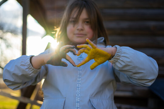 A child with the flag of Ukraine. Sadness longing hope. Children's sadness from the war. Evacuation of civilians. Freedom to Ukraine.
Hands painted in Ukraine flag - Powered by Adobe