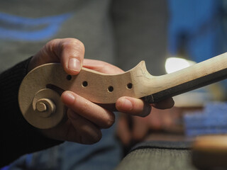 luthier working with a classic violin scroll - violinmaking art concept