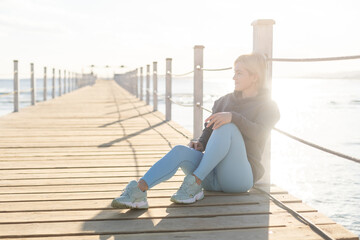 Female tourist walk and chill on wooden bridge as surround sea and beach