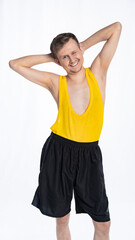 fitness man with a thin body, an athlete in black shorts and a yellow t-shirt threw his hands behind his head. The concept of sports motivation for training.