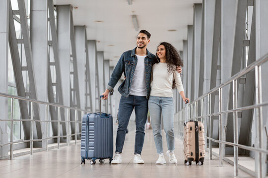 Portrait Of Smiling Arab Travellers Couple Standing With Suitcases At Airport