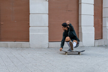 Caucasian skateboarder enjoying while riding skateboard in the downtown.