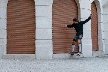 Caucasian skater guy having fun while riding skateboard in the downtown.