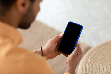 Young guy using cell with empty screen, mockup