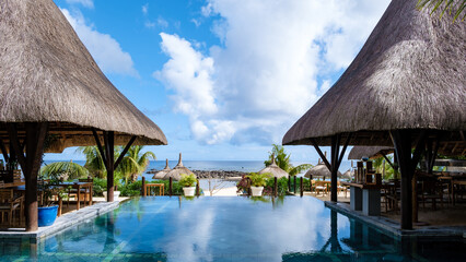 tropical pool with beach chairs and umbrellas, swimming pool in Mauritius at a sunny day