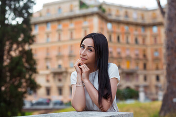 Fototapeta premium Young pretty woman in stylish summer dress posing outside at sunny day. Vacation and female fashion city lifestyle concept