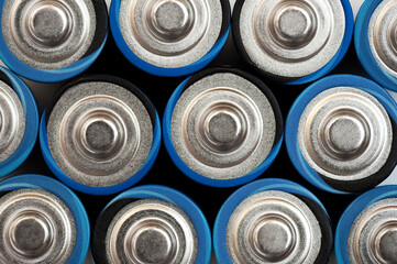 Alkaline batteries stand close to each other and form the background. Energy source. Lots of AA batteries