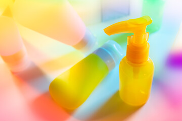 Cosmetic product creative still life. Colorful Cosmetic package collection on abstract spectrum...