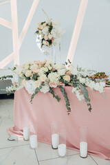 Wedding table decor with pastel colors. White roses and candles