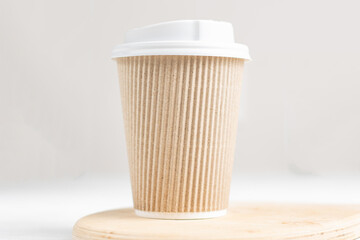 Coffee in paper cup on wood board. Take and go